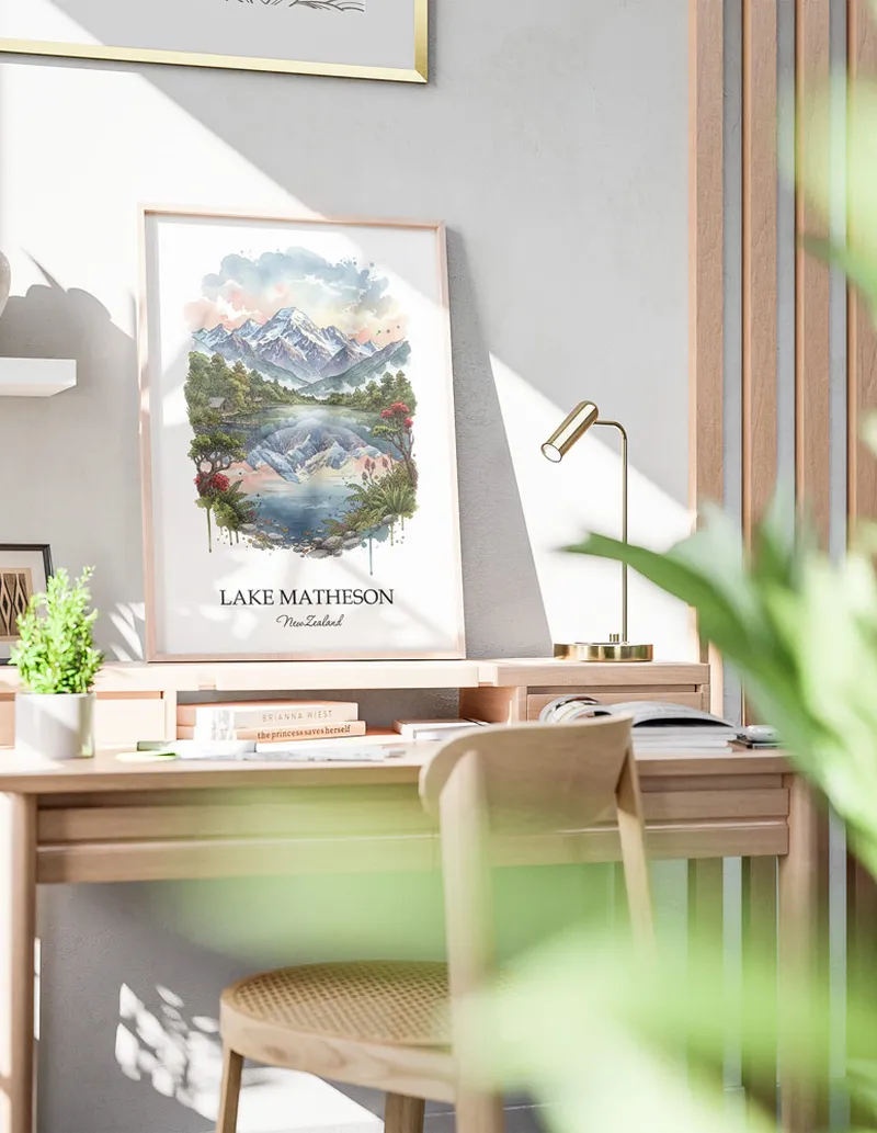 Minimalist poster of Lake Matheson in New Zealand in a light frame standing by a window in a boho style room.