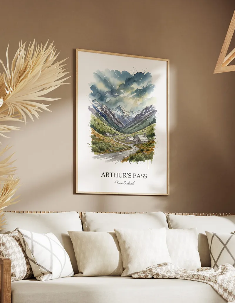 Minimalist poster of Arthur's Pass in New Zealand in a light frame standing on the floor in a dark moody interior.