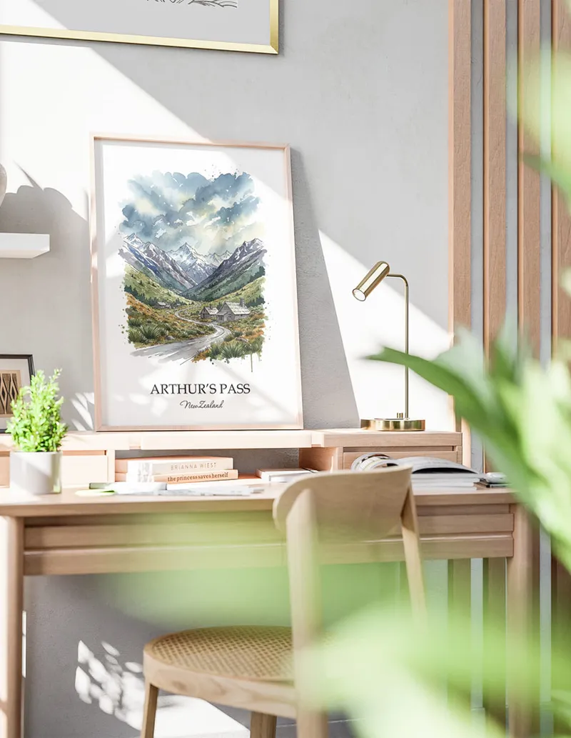 Minimalist poster of Arthur's Pass in New Zealand in a light frame standing by a window in a boho style room.