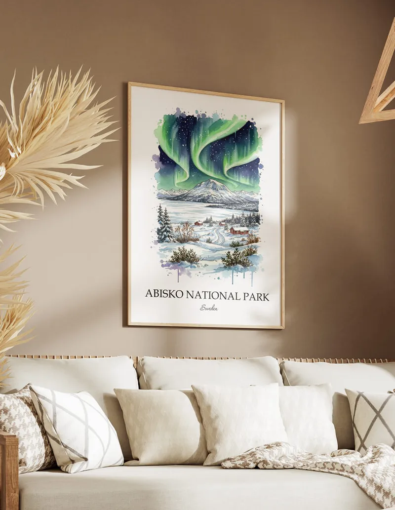 Vintage travel poster of Abisko National Park, Sweden in a light frame displayed above a sofa in a bright boho interior.