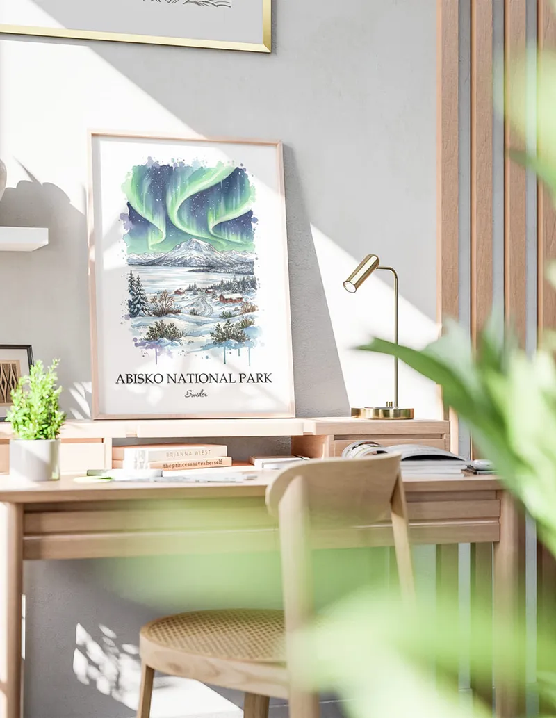 Cozy, well-lit workspace with a minimalist poster of Abisko National Park, Sweden in a light frame sitting on the desk.
