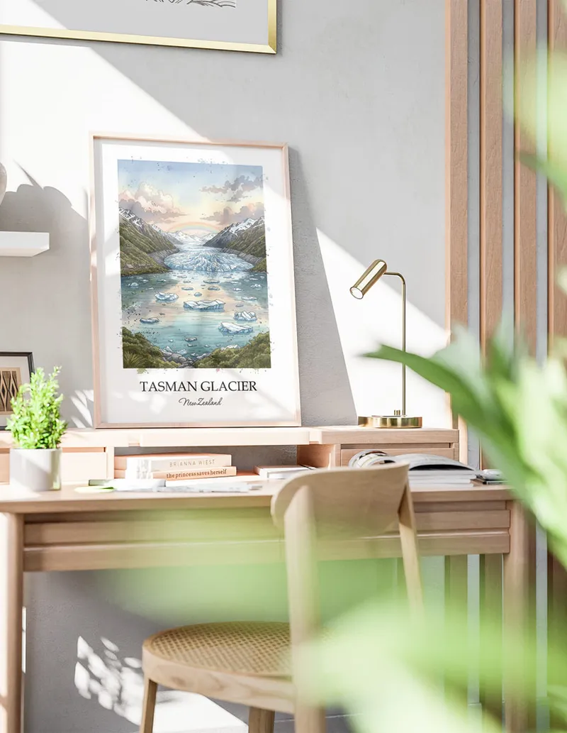 Minimalist poster of Tasman Glacier in New Zealand in a light frame standing by a window in a boho style room.
