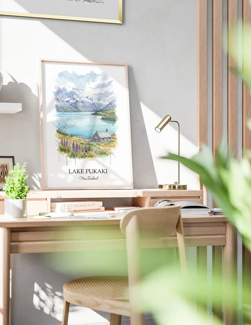 Minimalist poster of Lake Pukaki in New Zealand in a light frame standing by a window in a boho style room.
