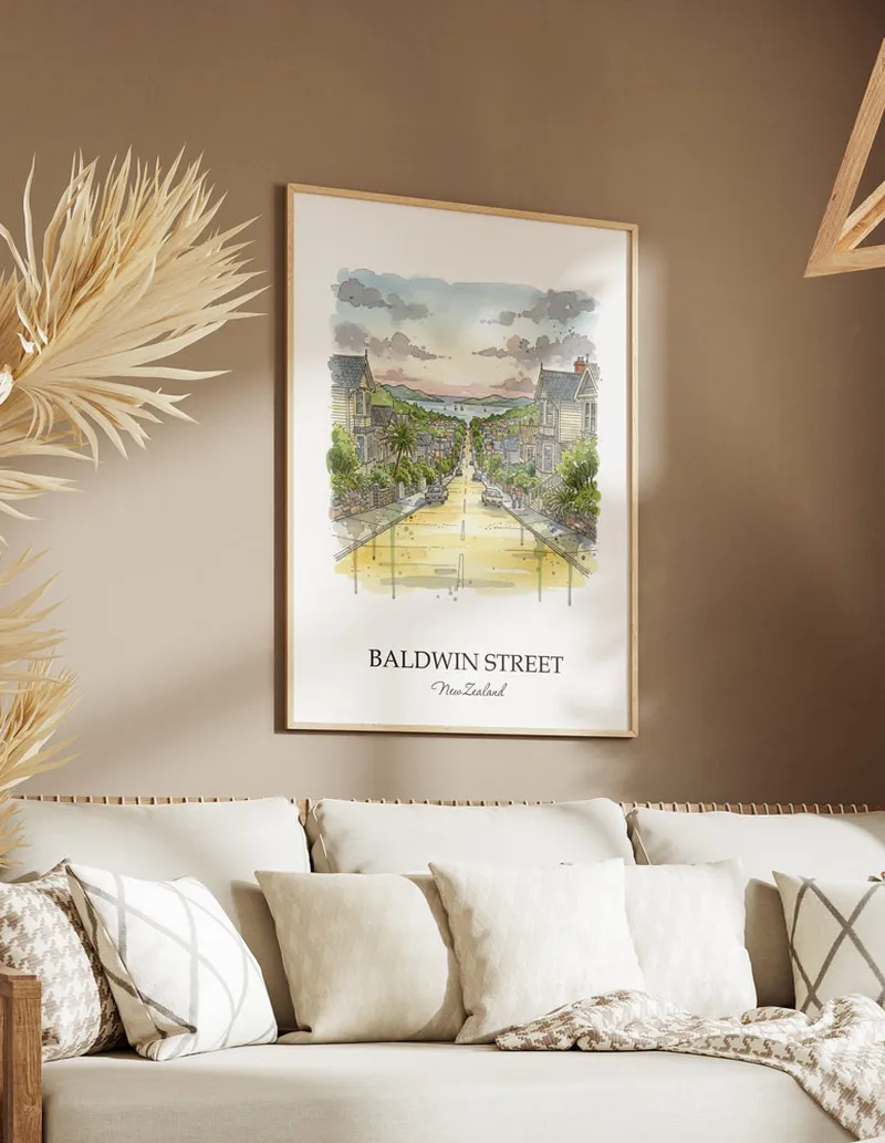Minimalist poster of Baldwin Street in New Zealand in a light frame standing on the floor in a dark moody interior.