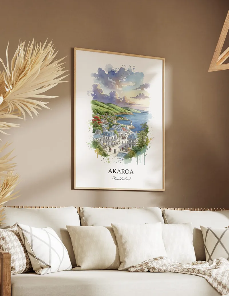 Minimalist poster of Akaroa in New Zealand in a light frame standing on the floor in a dark moody interior.