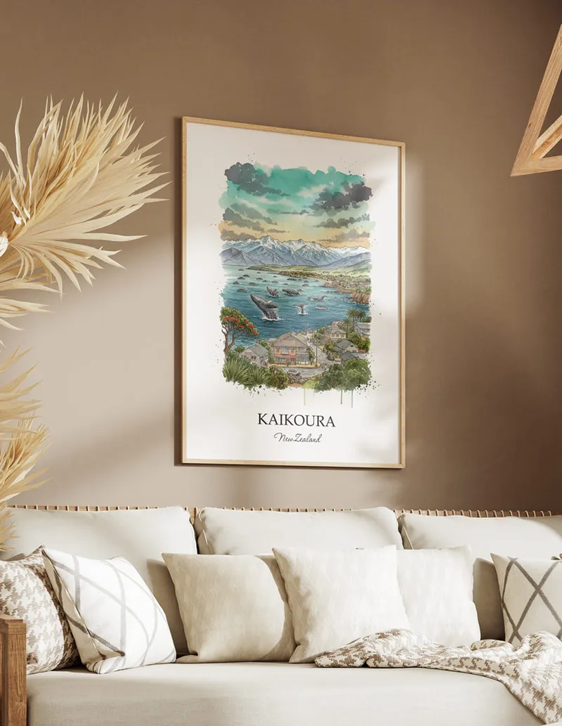 Minimalist poster of Kaikoura in New Zealand in a light frame standing on the floor in a dark moody interior.