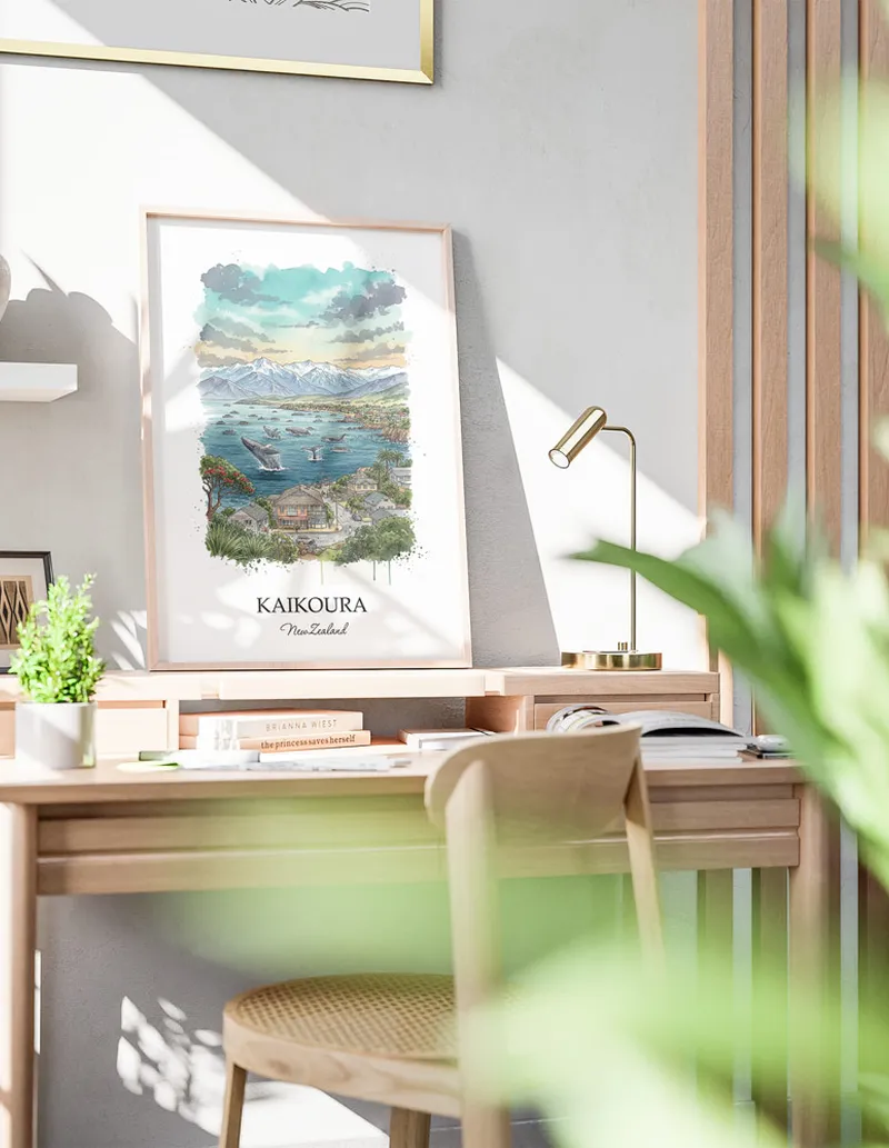 Minimalist poster of Kaikoura in New Zealand in a light frame standing by a window in a boho style room.