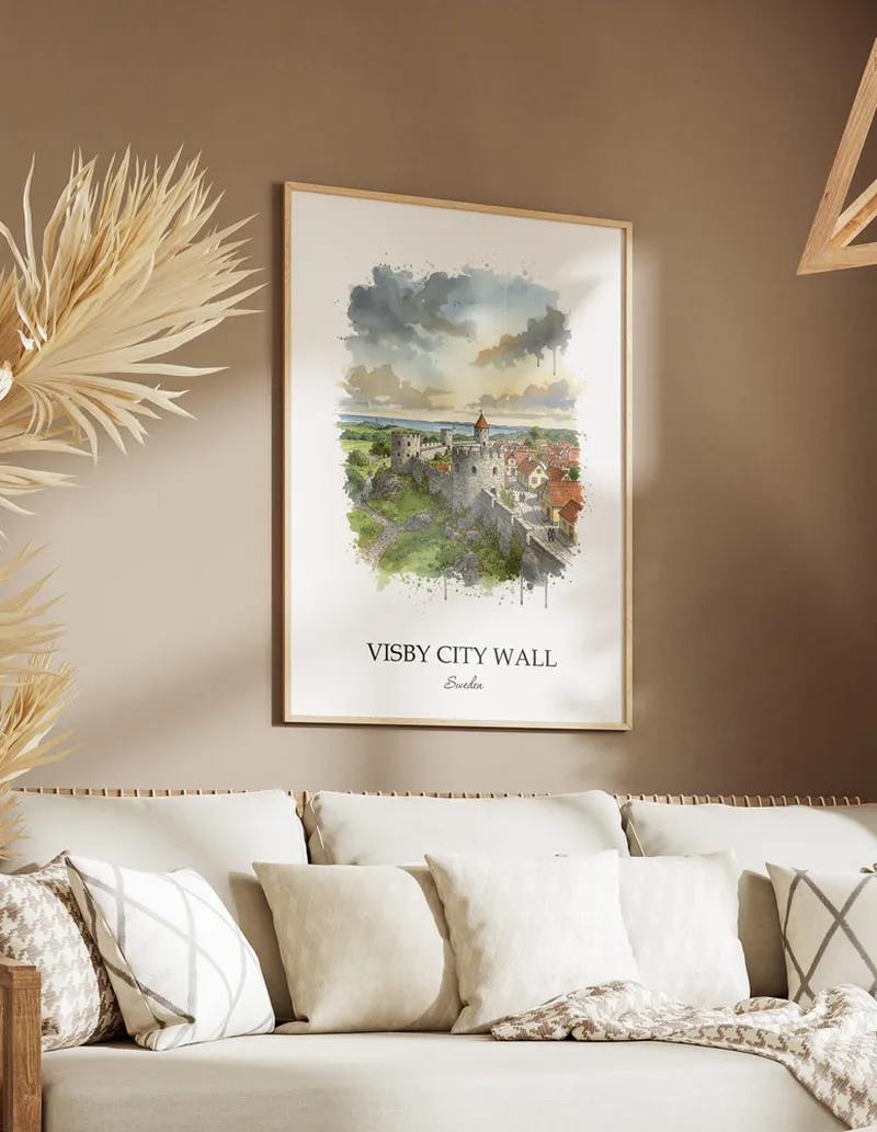 Vintage travel poster of Visby City Wall, Sweden in a light frame displayed above a sofa in a bright boho interior.