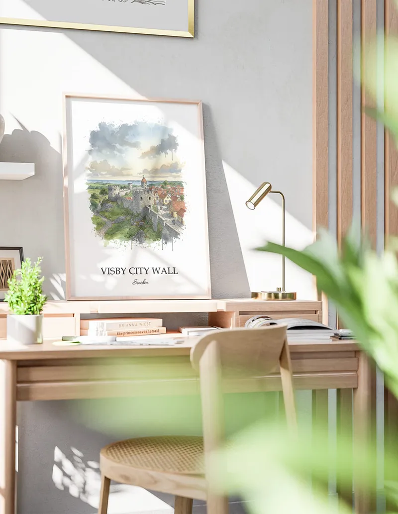 Cozy, well-lit workspace with a minimalist poster of Visby City Wall, Sweden in a light frame sitting on the desk.