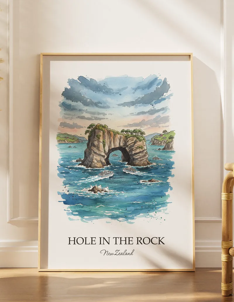 A gorgeous boho-inspired living space with a framed vintage travel poster of Hole in the Rock in New Zealand on display.