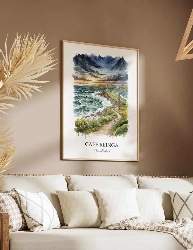 Minimalist poster of Cape Reinga in New Zealand in a light frame standing on the floor in a dark moody interior.