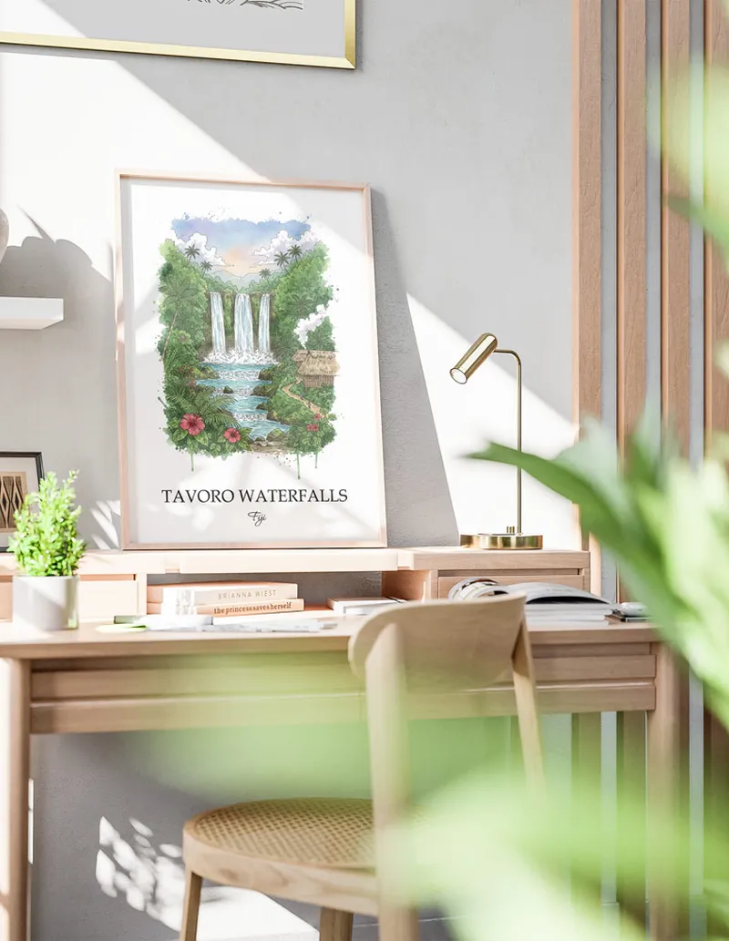 Framed wall art featuring Tavoro Waterfalls, Fiji in a light wood frame hanging above a sofa in a modern living room.