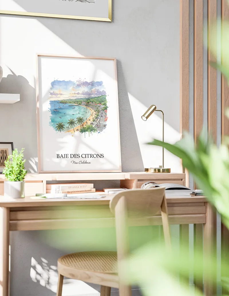 Framed wall art featuring Baie des Citrons, New Caledonia in a light wood frame hanging above a sofa in a modern living room.