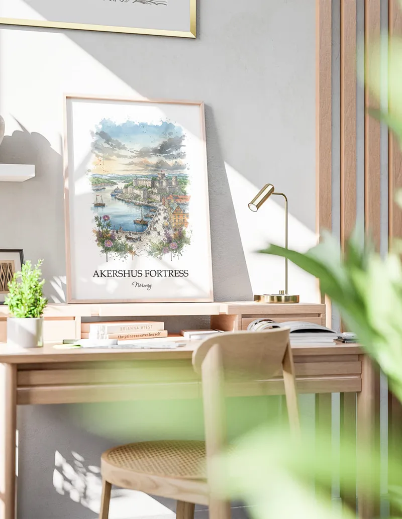 Cozy, well-lit workspace with a minimalist poster of Akershus Fortress, Norway in a light frame sitting on the desk.