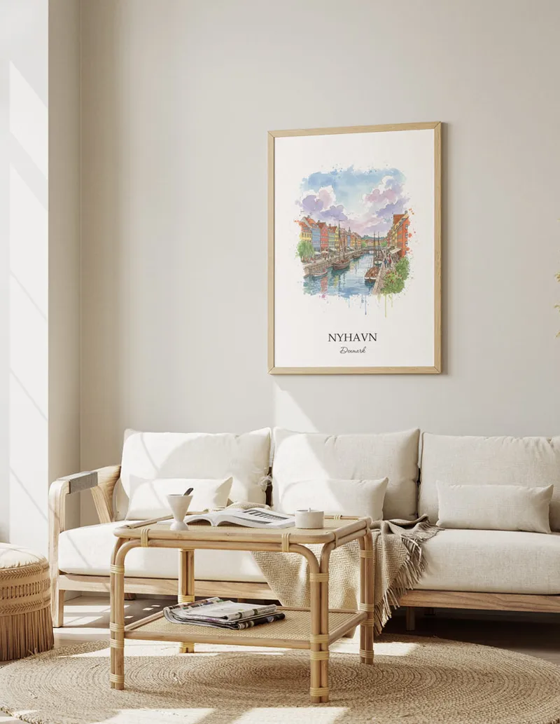 Framed wall art featuring Nyhavn, Denmark in a light wood frame hanging above a sofa in a modern living room.