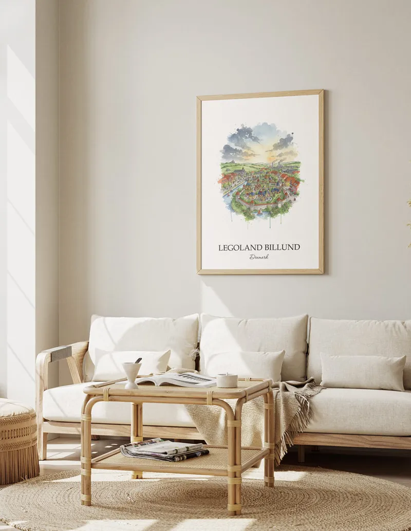 Framed wall art featuring Legoland Billund, Denmark in a light wood frame hanging above a sofa in a modern living room.