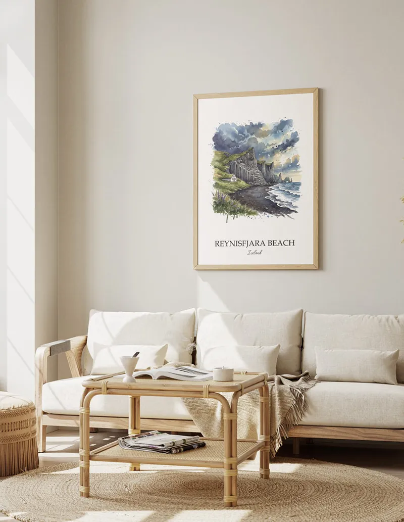 Framed wall art featuring Reynisfjara Beach, Iceland in a light wood frame hanging above a sofa in a modern living room.