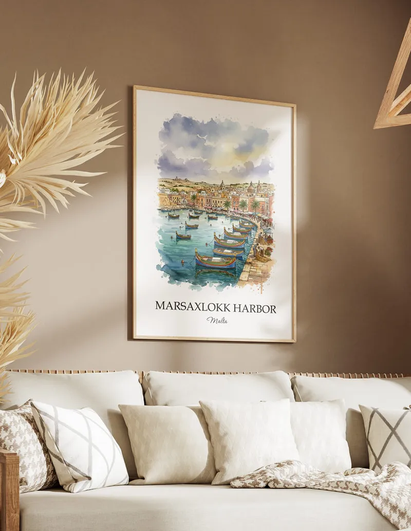 Vintage travel poster of Marsaxlokk Harbor, Malta in a light frame displayed above a sofa in a bright boho interior.