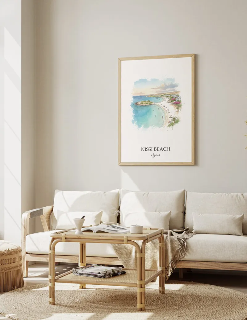 Vintage travel poster of Nissi Beach, Cyprus in a light frame displayed above a sofa in a bright boho interior.