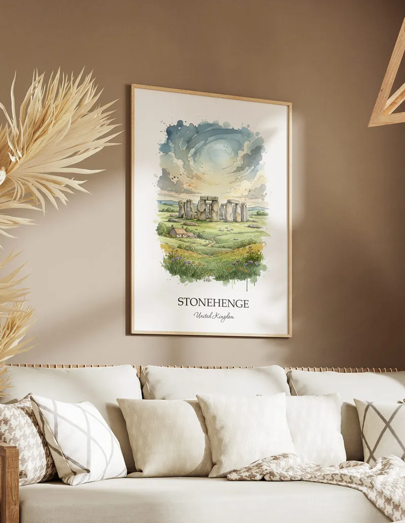 Vintage travel poster of Stonehenge, United Kingdom in a light frame displayed above a sofa in a bright boho interior.