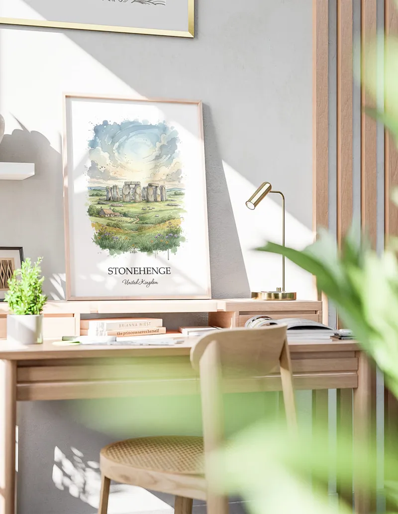 Cozy, well-lit workspace with a minimalist poster of Stonehenge, United Kingdom in a light frame sitting on the desk.