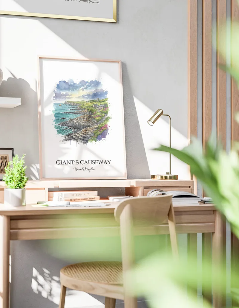 Cozy, well-lit workspace with a minimalist poster of Giant's Causeway, United Kingdom in a light frame sitting on the desk.