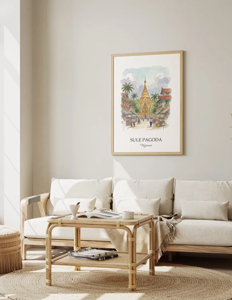 Vintage travel poster of Sule Pagoda, Myanmar in a light frame displayed above a sofa in a bright boho interior.