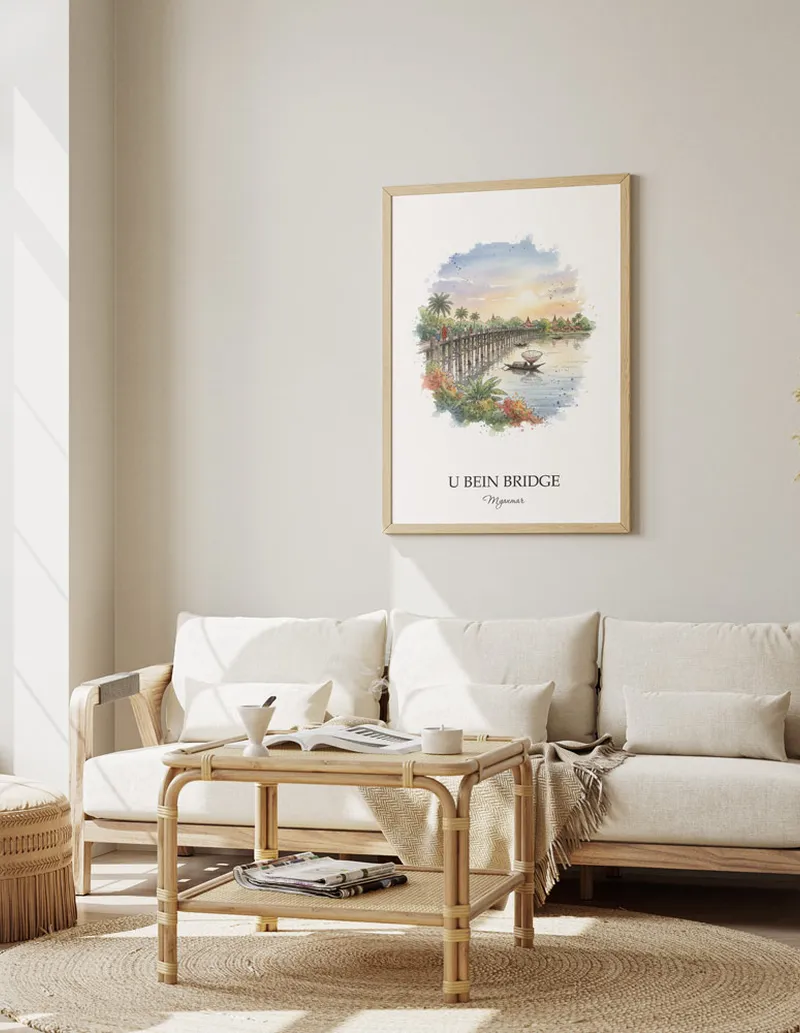 Vintage travel poster of U Bein Bridge, Myanmar in a light frame displayed above a sofa in a bright boho interior.