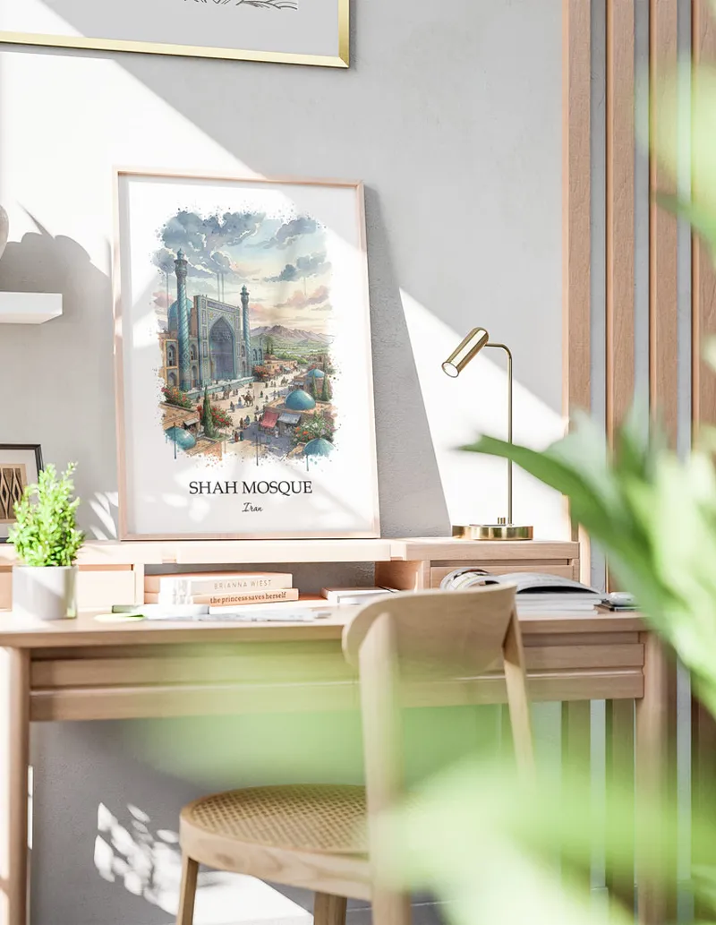 Cozy, well-lit workspace with a minimalist poster of Shah Mosque, Iran in a light frame sitting on the desk.