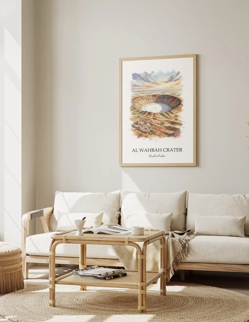 Vintage travel poster of Al Wahbah Crater, Saudi Arabia in a light frame displayed above a sofa in a bright boho interior.
