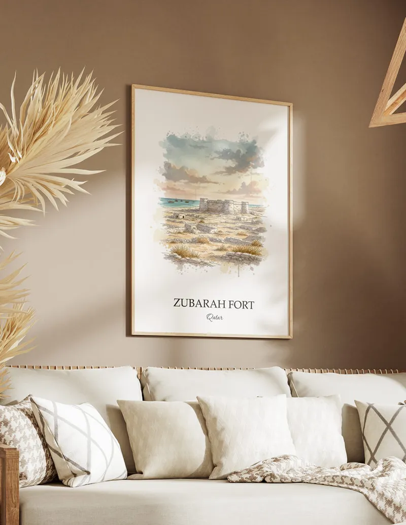A gorgeous boho-inspired living space with a framed vintage travel poster of Zubarah Fort in Qatar on display.