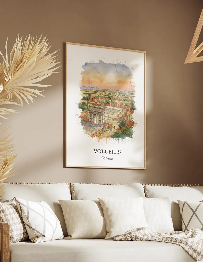 Cozy, well-lit workspace with a minimalist poster of Volubilis, Morocco in a light frame sitting on the desk.