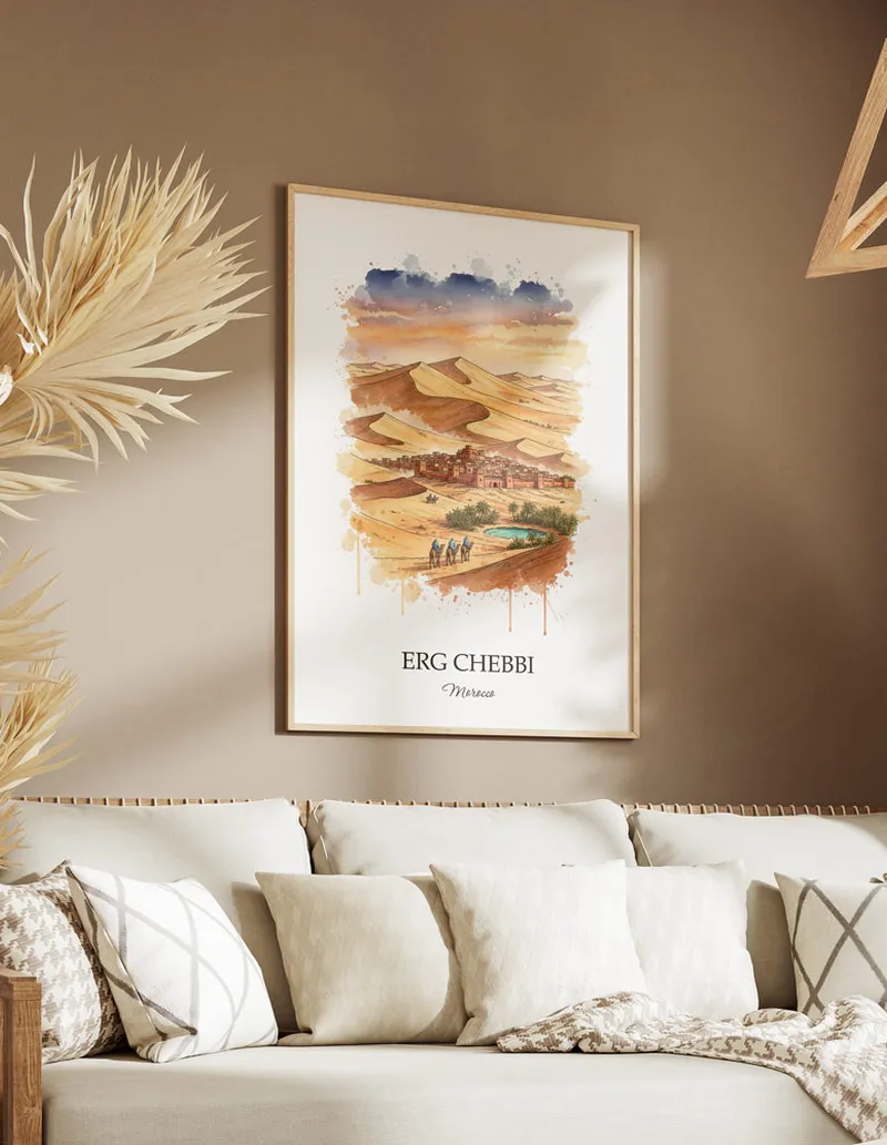 Cozy, well-lit workspace with a minimalist poster of Erg Chebbi, Morocco in a light frame sitting on the desk.
