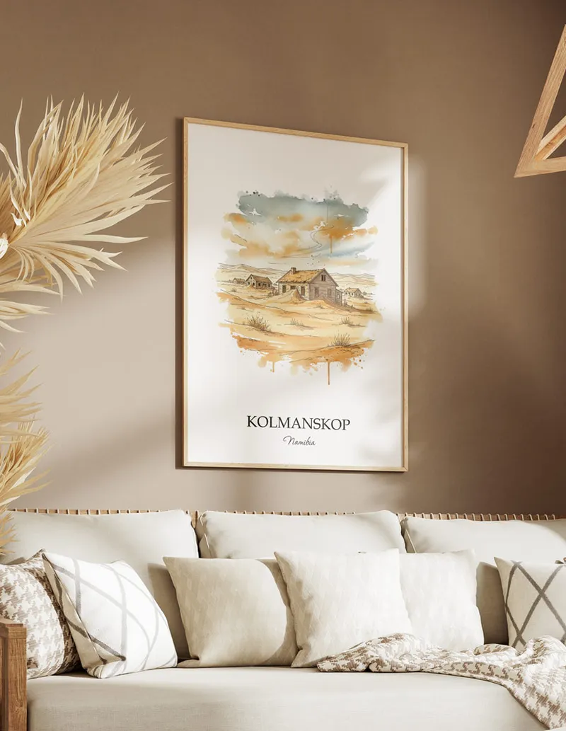 Cozy, well-lit workspace with a minimalist poster of Kolmanskop, Namibia in a light frame sitting on the desk.