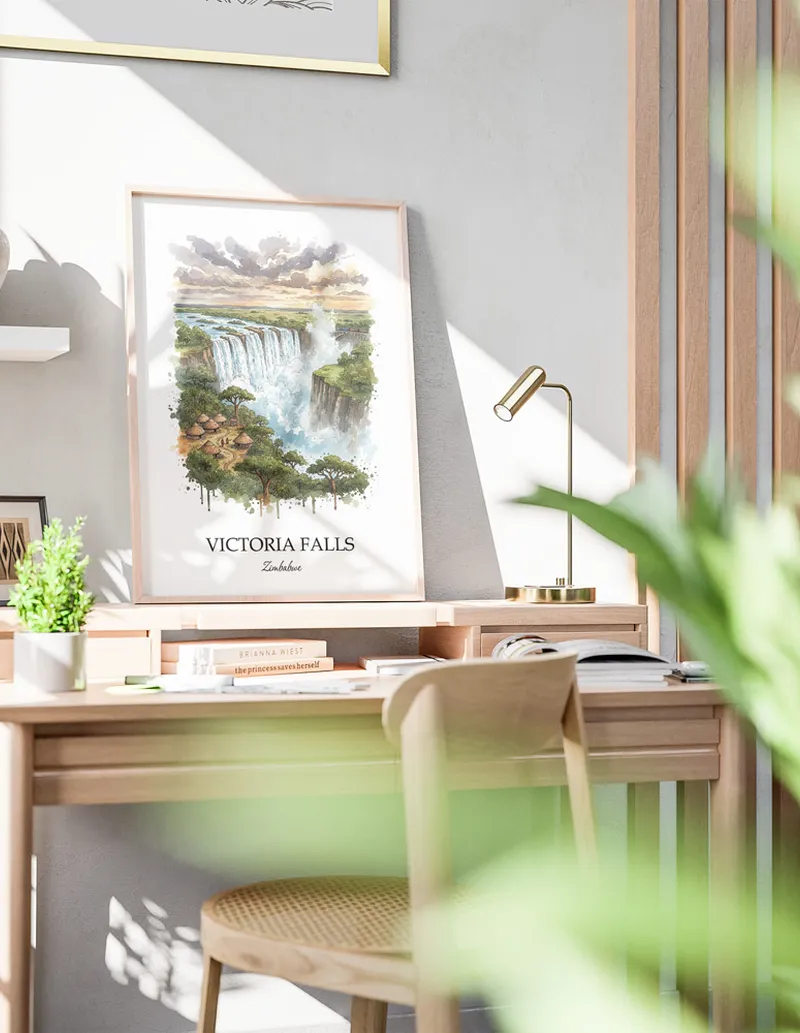 Framed wall art featuring Victoria Falls in Zimbabwe in a light wood frame leaning on the floor.