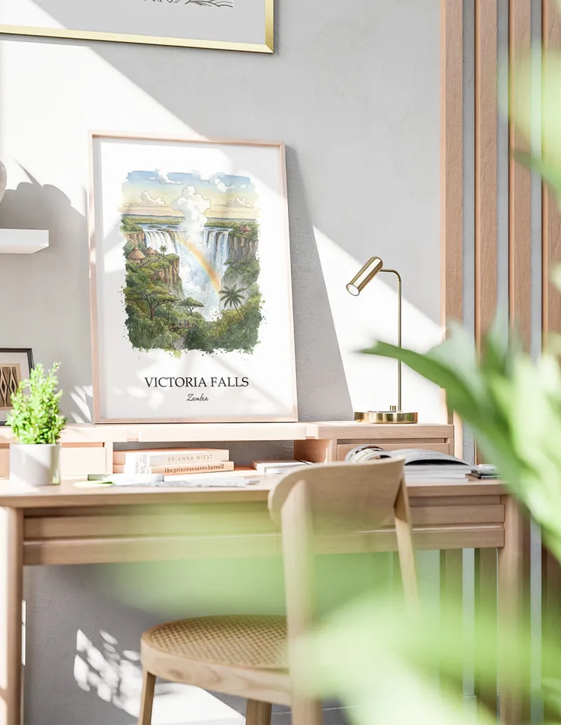 Framed wall art featuring Victoria Falls in Zambia in a light wood frame leaning on the floor.