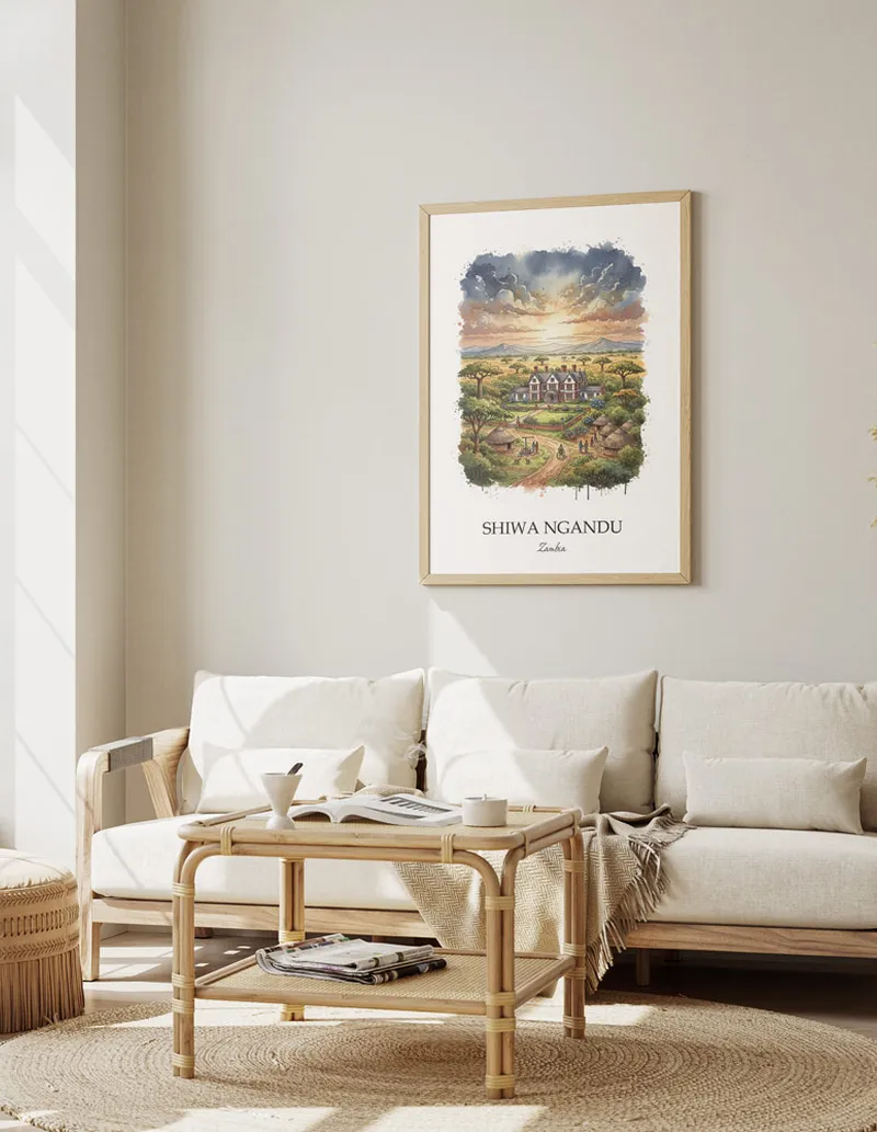 Cozy, well-lit workspace with a minimalist poster of Shiwa Ngandu, Zambia in a light frame sitting on the desk.