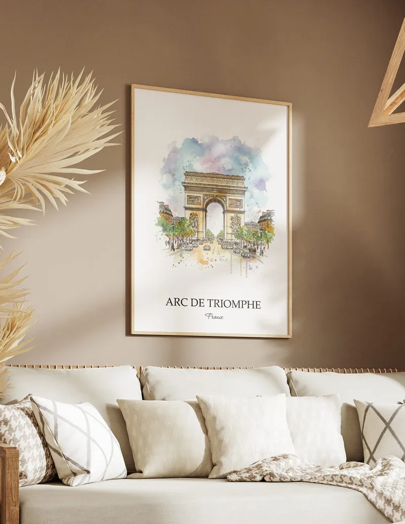 Vintage travel poster of Arc de Triomphe, France in a light frame displayed above a sofa in a bright boho interior.
