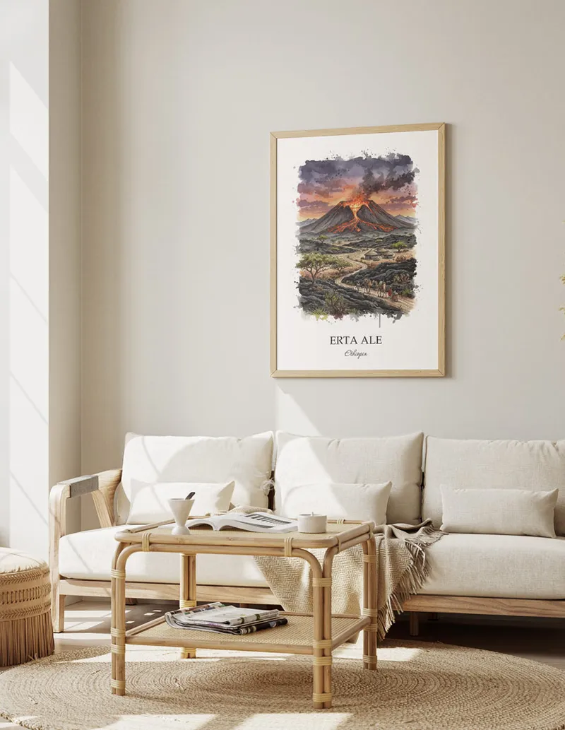 Cozy, well-lit workspace with a minimalist poster of Erta Ale, Ethiopia in a light frame sitting on the desk.