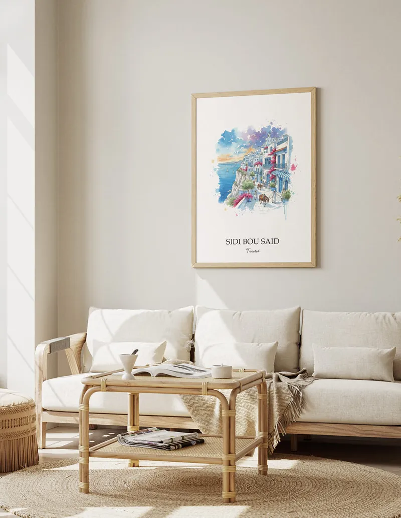 Vintage travel poster of Sidi Bou Said, Tunisia in a light frame displayed above a sofa in a bright boho interior.
