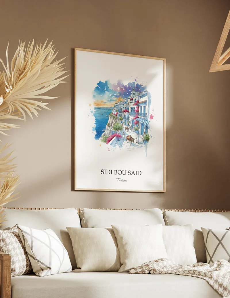 A gorgeous boho-inspired living space with a framed vintage travel poster of Sidi Bou Said in Tunisia on display.