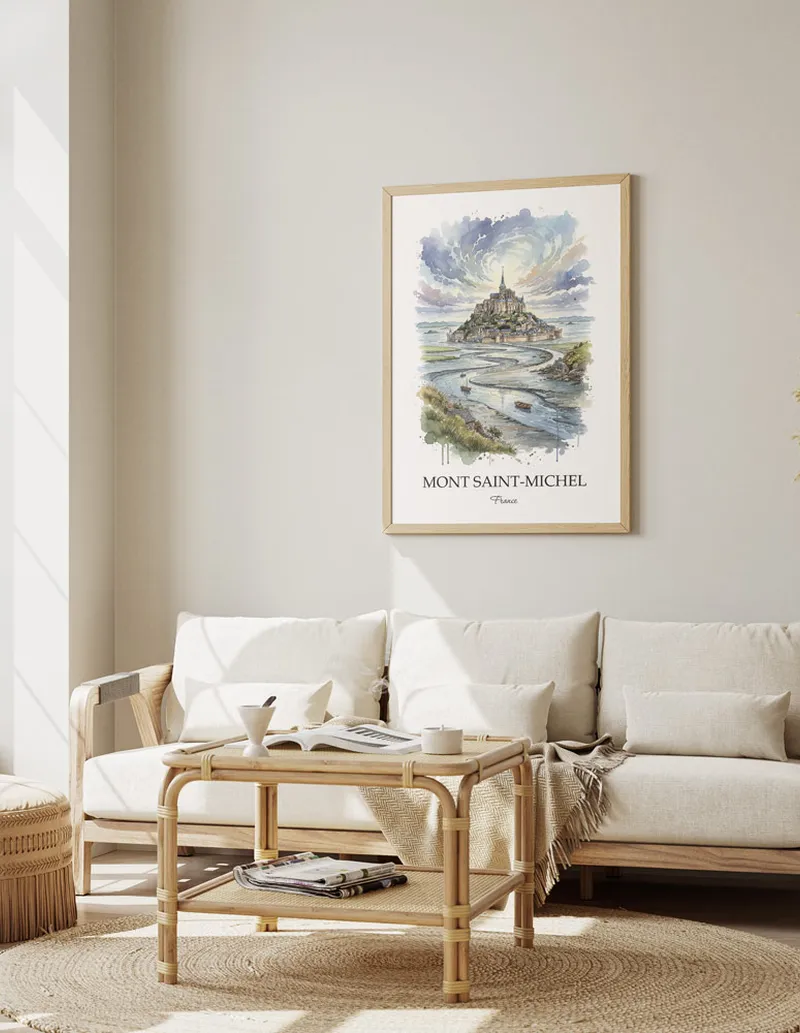 Framed wall art featuring Mont Saint-Michel, France in a light wood frame hanging above a sofa in a modern living room.