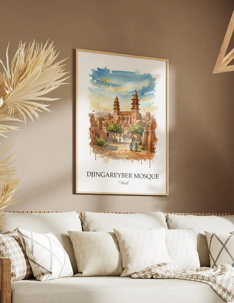 Cozy, well-lit workspace with a minimalist poster of Djingareyber Mosque, Mali in a light frame sitting on the desk.