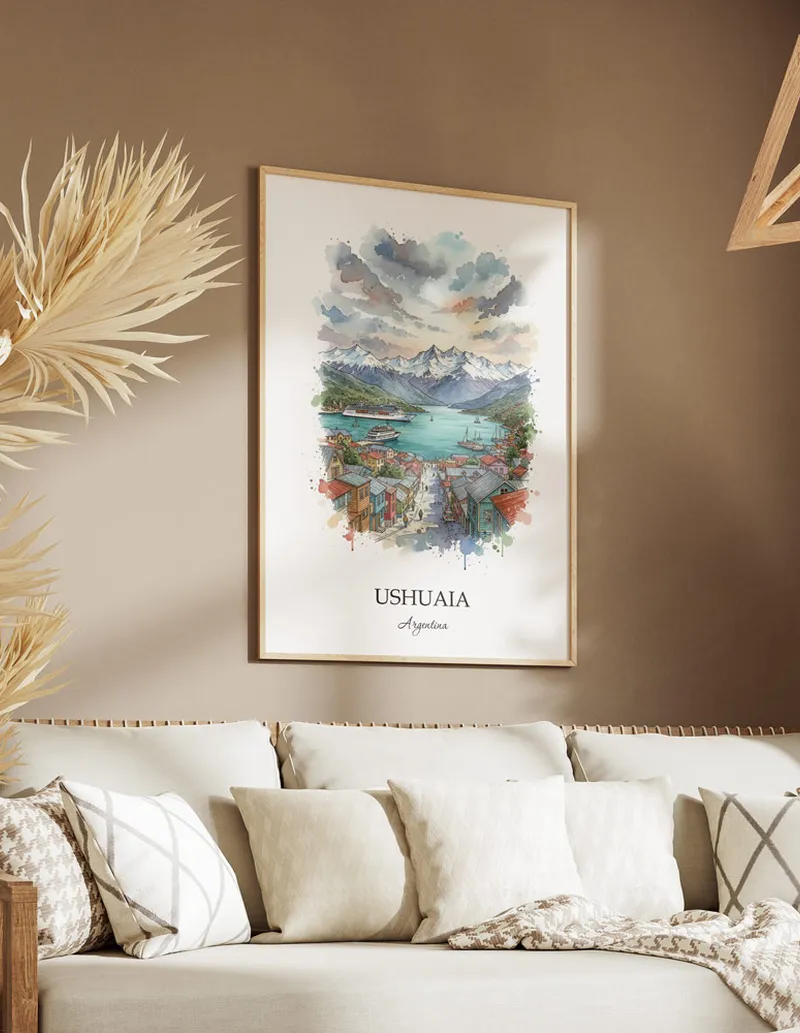 Vintage travel poster of Ushuaia, Argentina in a light frame displayed above a sofa in a bright boho interior.