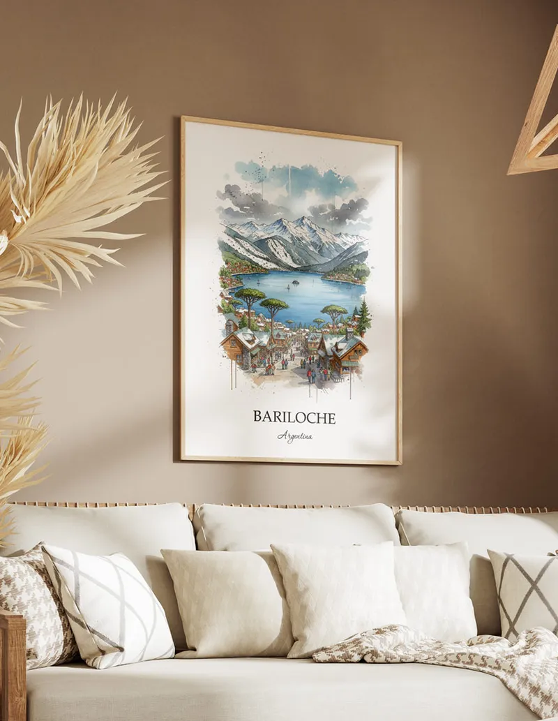 Vintage travel poster of Bariloche, Argentina in a light frame displayed above a sofa in a bright boho interior.