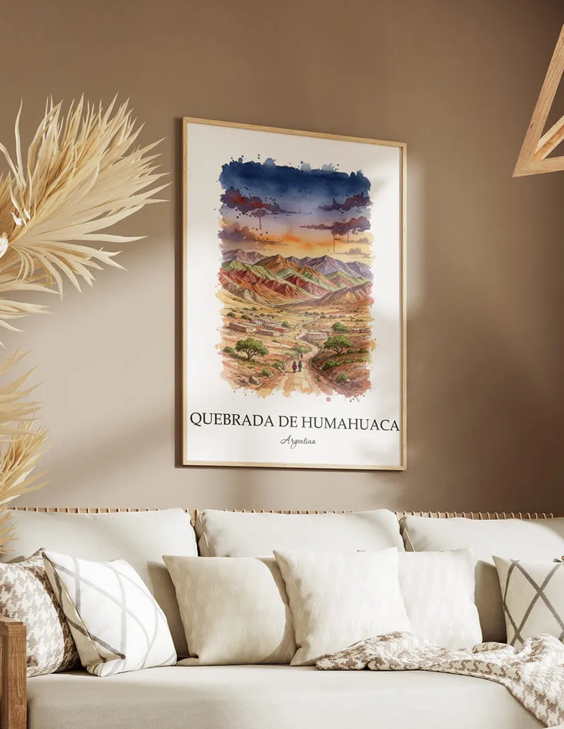 Vintage travel poster of Quebrada de Humahuaca, Argentina in a light frame displayed above a sofa in a bright boho interior.